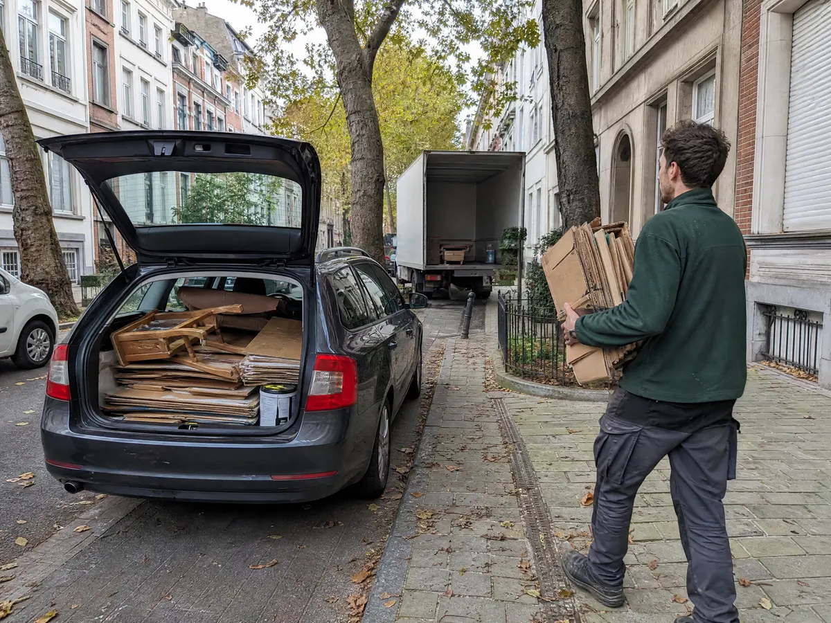Estate car in Forest, Brussels, with flattened cardboard, a broken chair and a paint tin sorted in the boot
